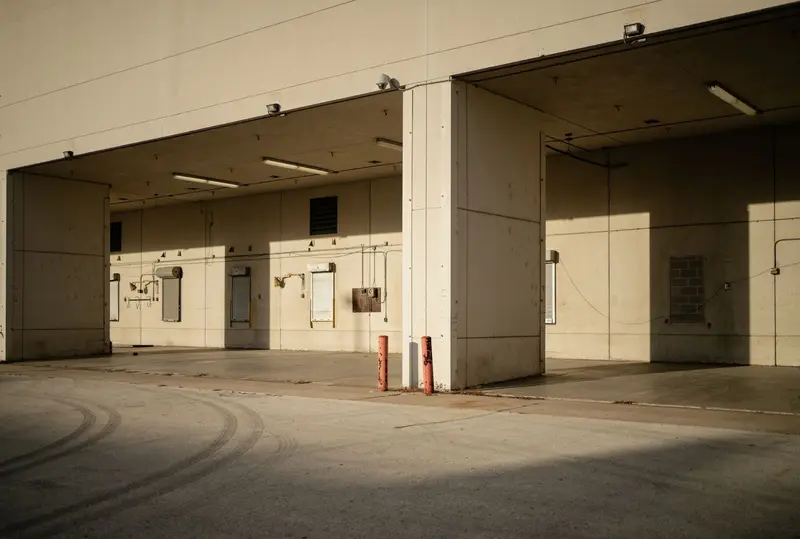 Empty covered loading bays of an industrial building in low afternoon sun